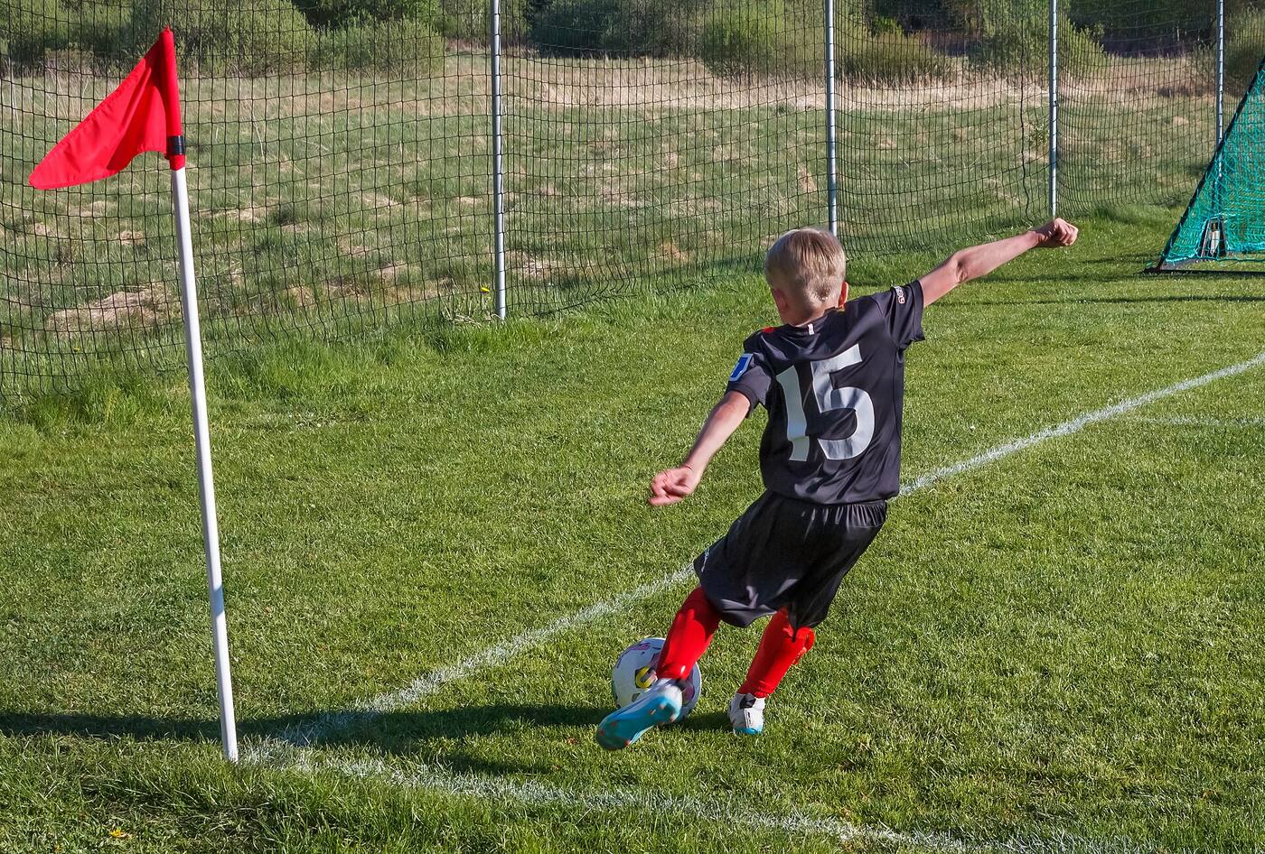 Junger Spieler schießt eine Ecke auf dem Trainingsplatz